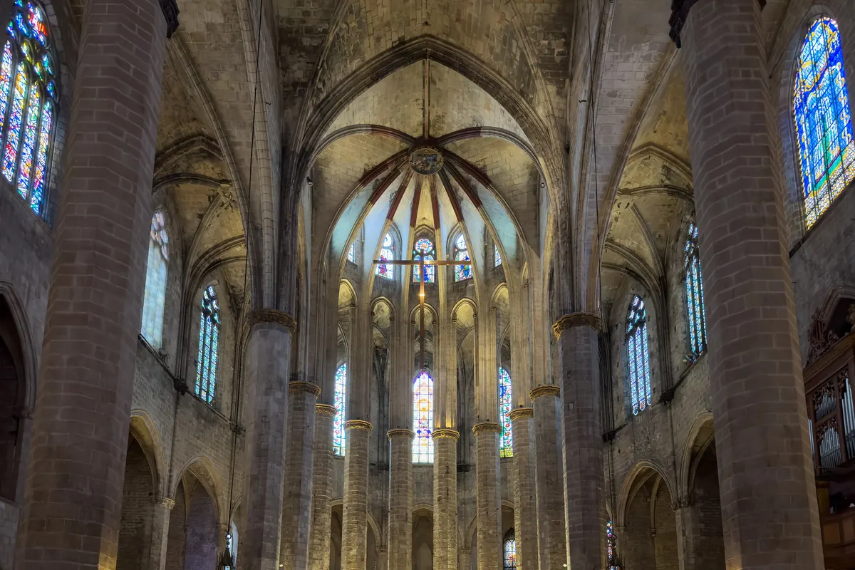 Inside Barcelona's Santa Maria del Mar, slender stone columns rise to a ribbed vault with stained glass between them